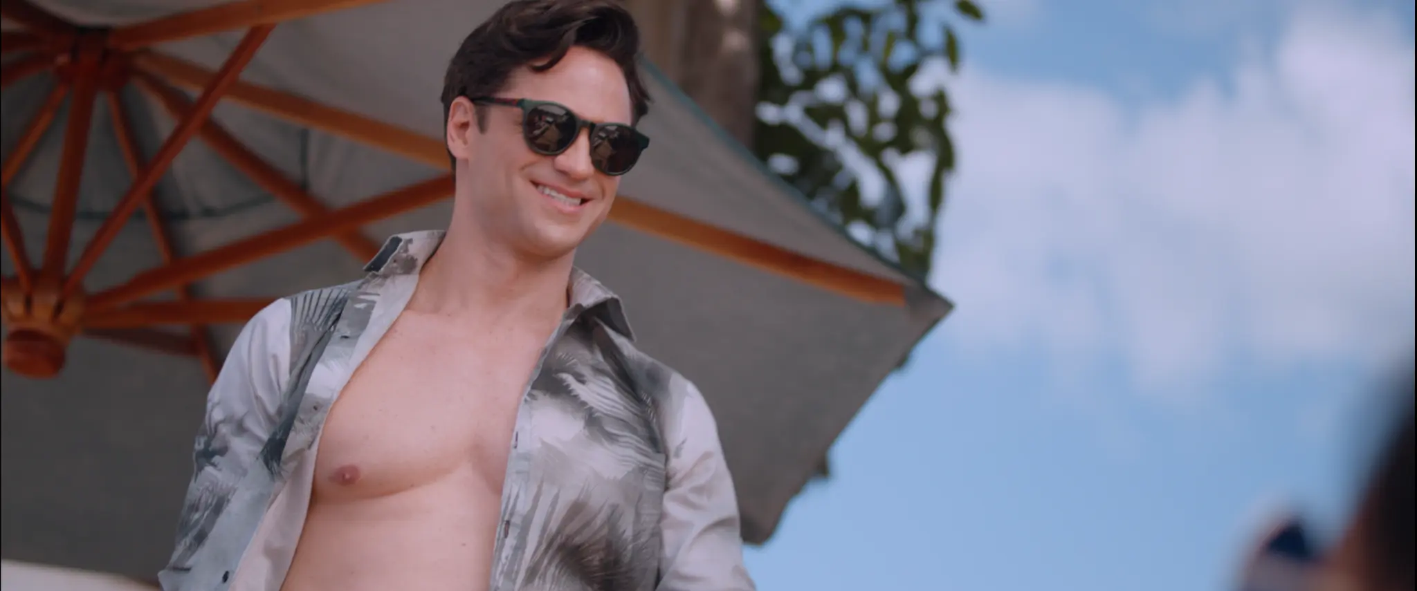 Homem de óculos escuros próximo à piscina