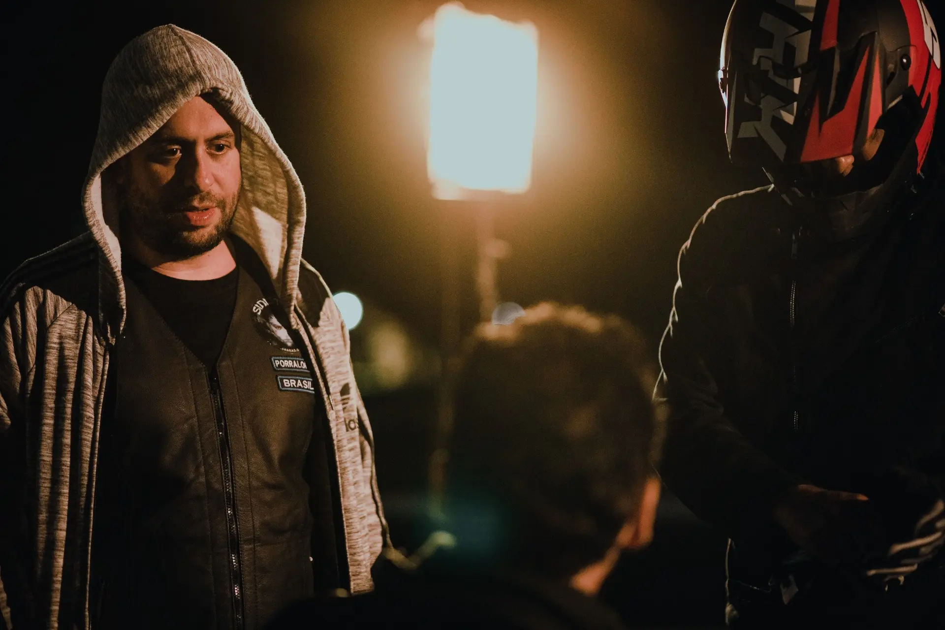 Atores aguardam uma tomada no set noturno