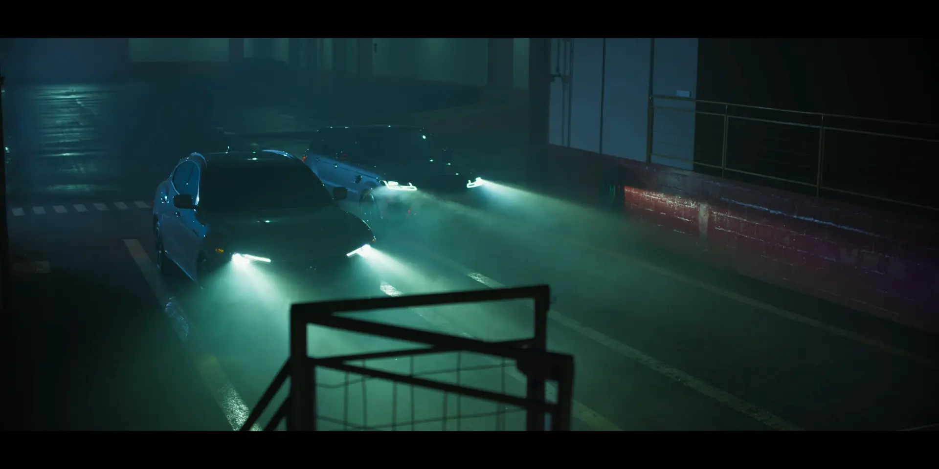 Carros avançam por um galpão durante a noite