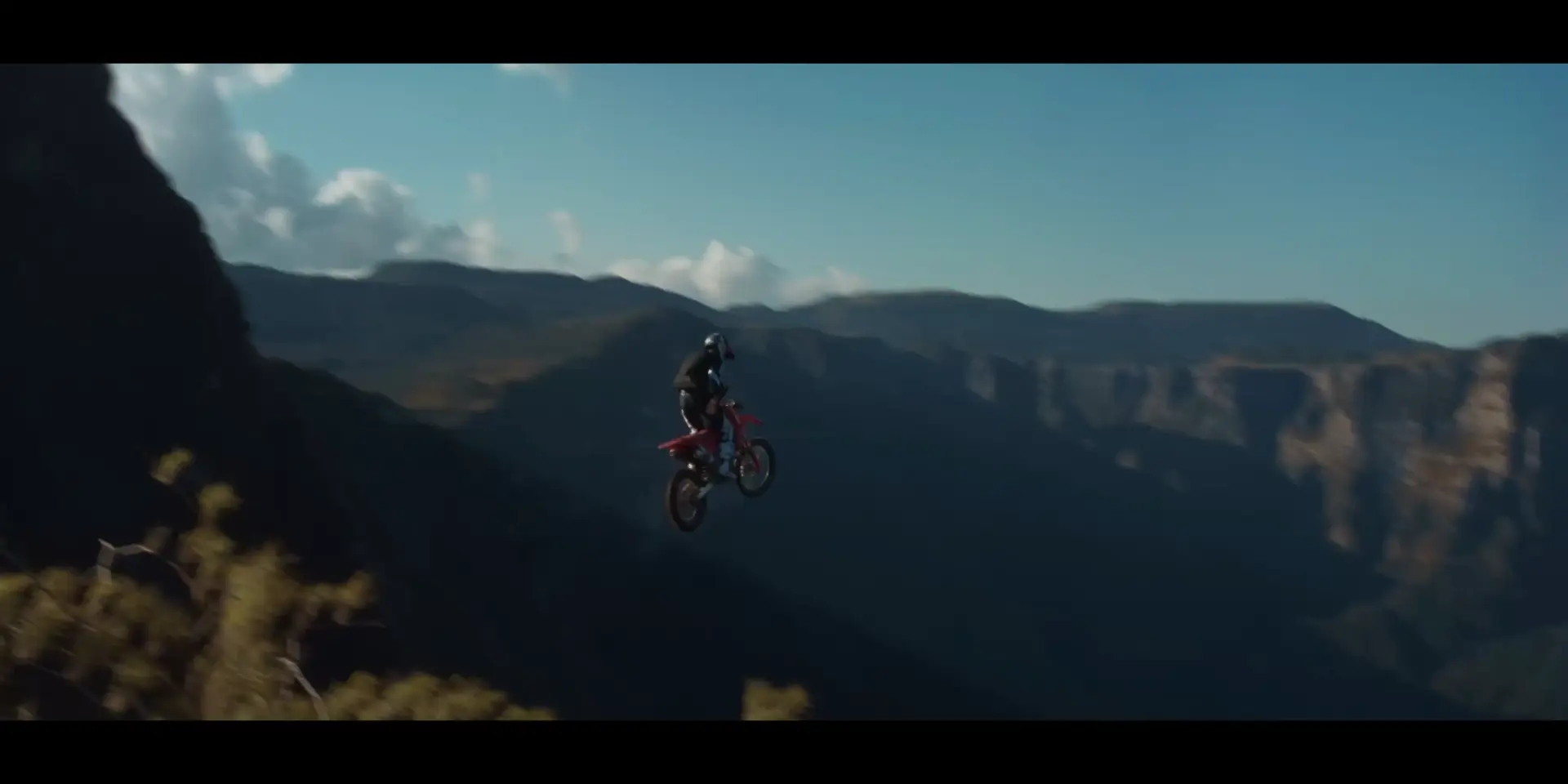 Motociclista salta sobre um cânion